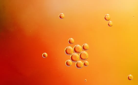 Abstract red, orange background from floating oil bubbles in the water.