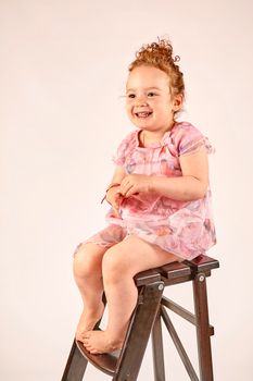 Fashion little girl in rose dress, in catwalk model pose, stock photo