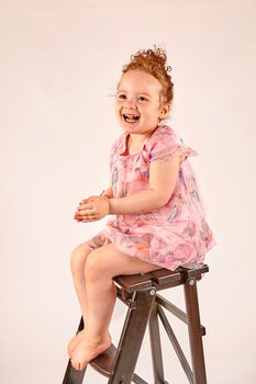 Fashion little girl in rose dress, in catwalk model pose, stock photo