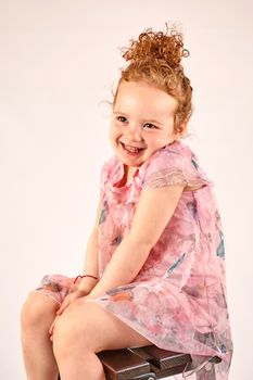 Fashion little girl in rose dress, in catwalk model pose, stock photo