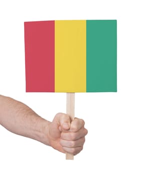 Hand holding small card, isolated on white - Flag of Guinea