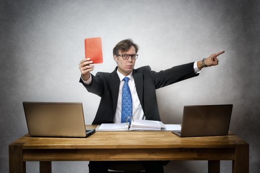 Image of angry and screaming business man with red card in hand in office