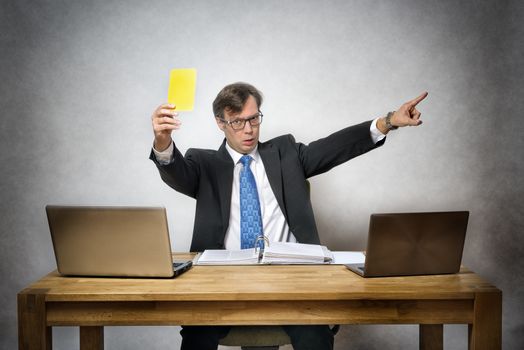 Image of business man with yellow card in office