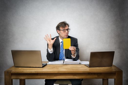 Image of business man with yellow card in office