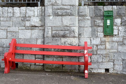 red bench against a wall in cobh county cork ireland