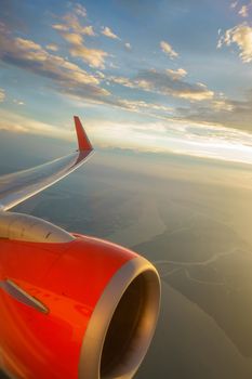 Airliner in flight at sunset, bright orange engine