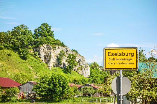 Eselsburg - town sign - with rocks of the famous Eselburger Tal valley in the background