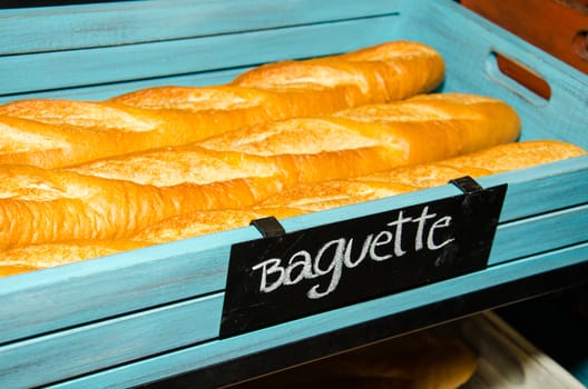 French bread baguette on wooden basket, made from flour.