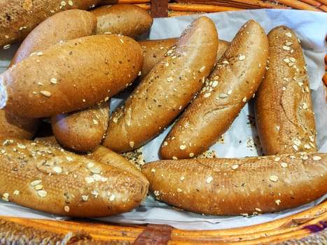 Freshly baked whole wheat buns on display in a basket at the bakery