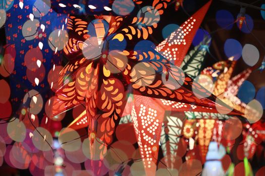 Start shaped lantern line through the colorful blur decoration lights during an Indian festival