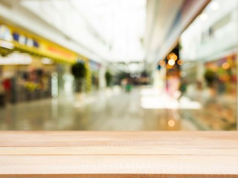 Wooden board empty table in front of blurred background. Perspective light wood over blur in shopping mall - can be used for display or montage your products. Mock up for display of product.