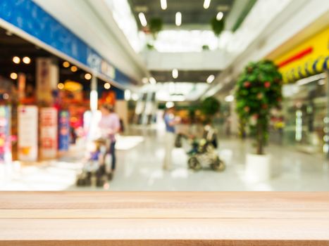 Wooden board empty table in front of blurred background. Perspective light wood over blur in shopping mall - can be used for display or montage your products. Mock up for display of product.