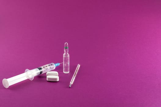 Closeup of medical tools and drugs on colored background