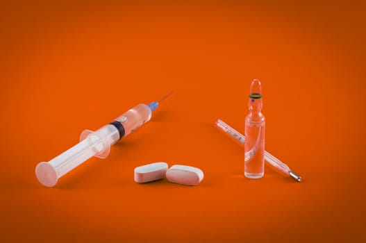 Closeup of medical tools and drugs on colored background