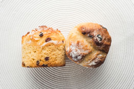 pair of homemade carrot muffins with empty space on white fabric background. Copyspace top view.