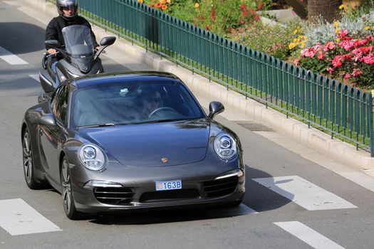 Monte-Carlo, Monaco - May 18, 2016: Beautiful Woman Driving an Expensive Porsche 911 Carrera S on Avenue Princesse Grace in Monte-Carlo, Monaco in the south of France