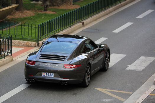 Monte-Carlo, Monaco - May 18, 2016: Luxury Black Porsche 911 Carrera S on Avenue Princesse Grace in Monte-Carlo, Monaco in the south of France
