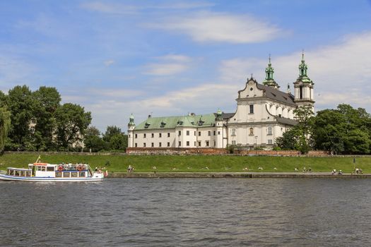 CRACOW,POLAND - JUNE 17, 2013 : Church on the Skalka and Vistula boulevards in old town in Krakow.  Place often visited by tourists and locals for purposes of relaxation on sunny days.
