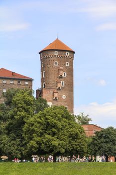 KRAKOW, POLAND - JUNE 17, 2013 : View on Wawel Royal Castle and Vistula boulevards.  Place often visited by tourists and locals for purposes of relaxation on sunny days.
