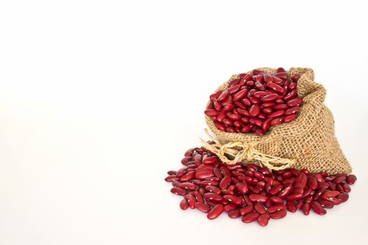 Red beans in canvas sack on white background