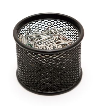 Paper clips in the black metal office pot on a white background.