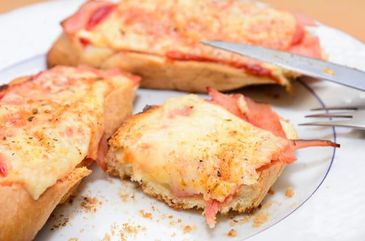 Remains of the ham and cheese baked toast on the plate.