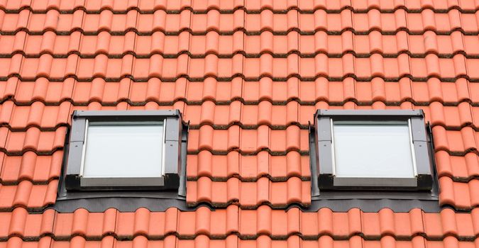 Orange roof with two classic garret windows.