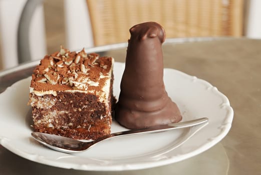 Closeup of the sweet chocolate dessert on the plate with spoon.