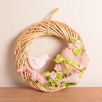 Interior decoration, wicker wreath with fabric bird, rose and ribbon.