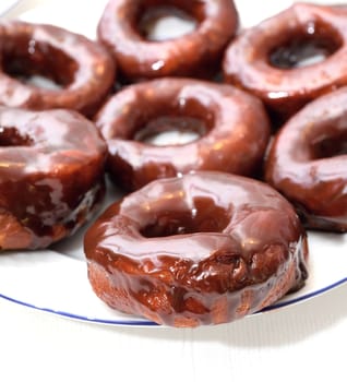 Sweet donuts on the plate with chocolate glaze.