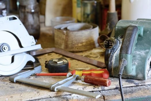 Tools on the workbench, screwdriver, meter and grinder.