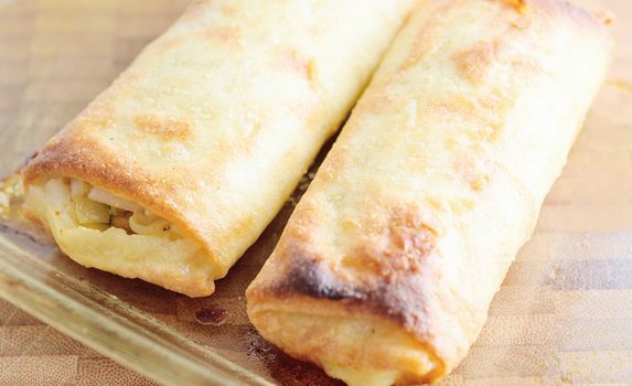 Chinese spring rolls on a wooden plate.