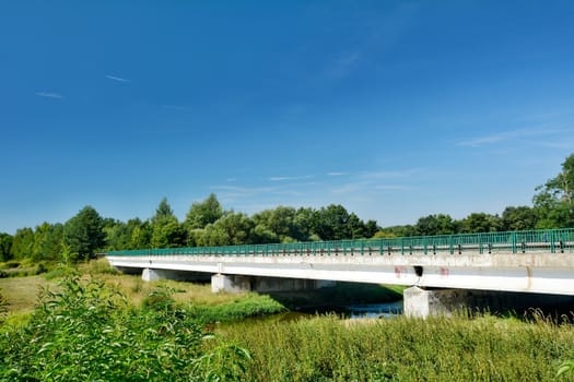 Old concrete road bridge over the river.