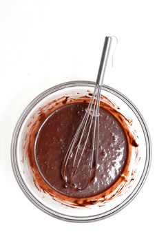 Mixing of a chocolate dough in a glass bowl for making a cake.