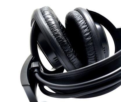 Black headphones on the white background. Closeup shot.