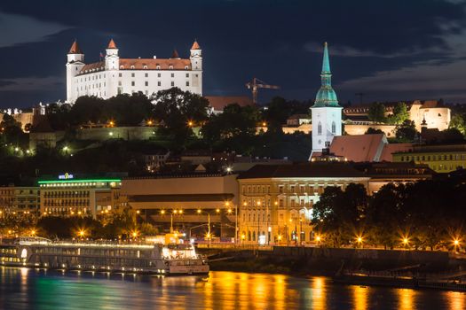 River Danube lining the old city of Bratislava, Slovakia. Night view on the hill with the castle and historical cathedral of St. Martin.