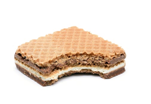 Bitten wafer with hazelnut and milk cream on white background.