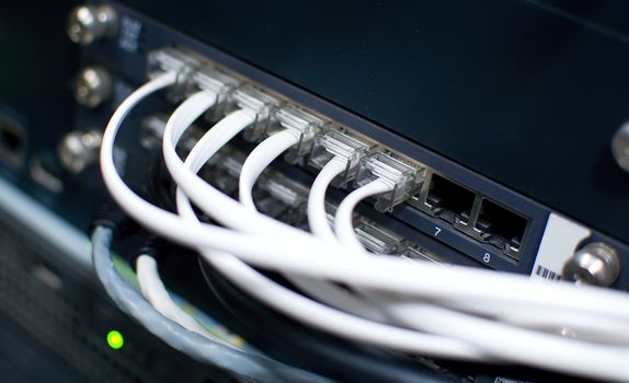 White telephone cables plug to the RJ45 phone port in telephone exchange. 