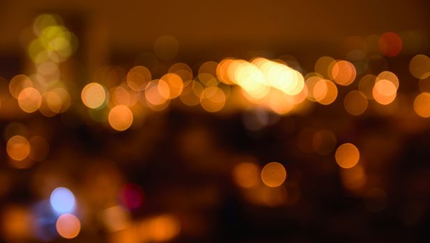 Abstract colorful defocused city lights with bokeh effects at night. Warm tone orange light background.