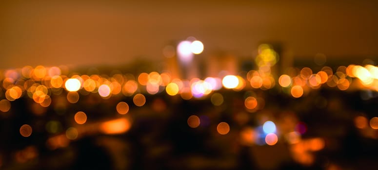 Abstract colorful defocused city lights with bokeh effects at night. Warm tone orange light background.