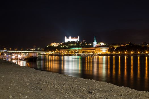 River Danube lining the old city of Bratislava, Slovakia. Night view on the hill with the castle and historical cathedral of St. Martin.