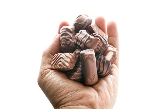 fine chocolates in white, dark, and milk chocolate in a hand