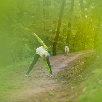 Sporty young female working out in forest.  Female runner during outdoor workout in nature. Fitness model outdoors. Weight Loss. Healthy lifestyle. 