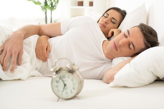 Young hugging couple sleeping on the bed in bedroom