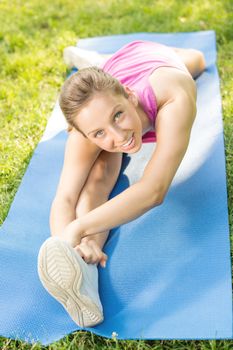 Cute girl doing stretching exercises in the park.