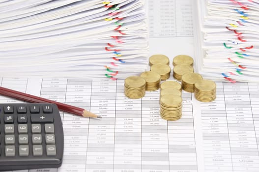 Step pile of gold coins and pencil with calculator on finance account have dual pile overload document of report with colorful paperclip as background.