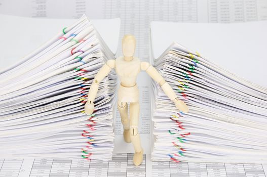 Wooden dummy try to escape from dual pile overload document of report with colorful paperclip on finance account.
