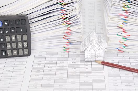 House and pencil on finance account have calculator place vertical and dual pile overload document of report with colorful paperclip as background.
