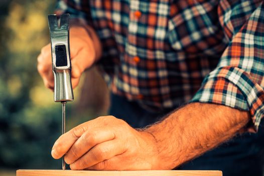 Man hammering nail outdoor