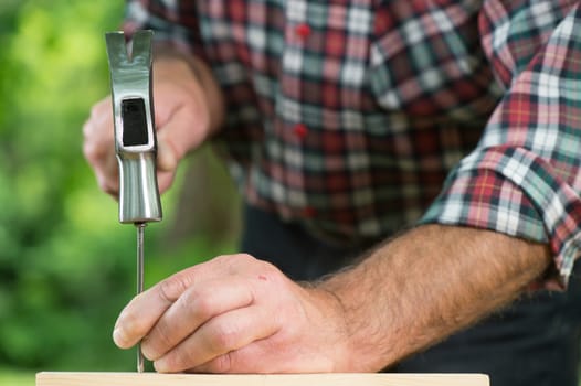 Man hammering nail outdoor